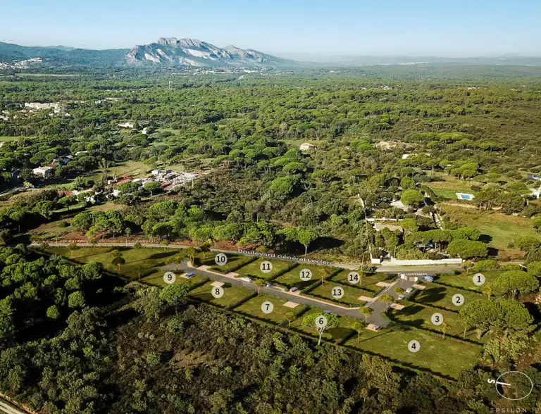 plan 3D en axonométrie d'un futur ensemble de terrains à construire, séparés par des haies, intégré dans un environnement de pins et montagnes au loin